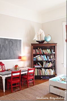 a living room filled with furniture and a chalkboard on the wall