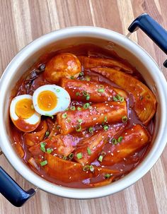 an overhead view of a bowl of food with meats and boiled eggs in it