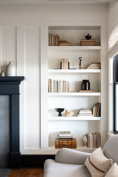 a living room filled with furniture and bookshelves next to a fire place in front of a fireplace