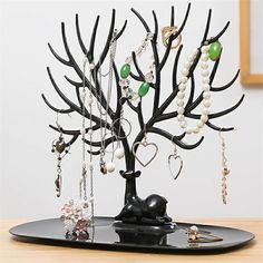 a jewelry tree on top of a black tray