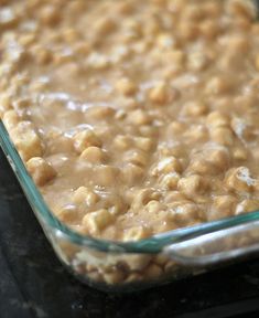 a glass casserole dish filled with food sitting on top of a black counter