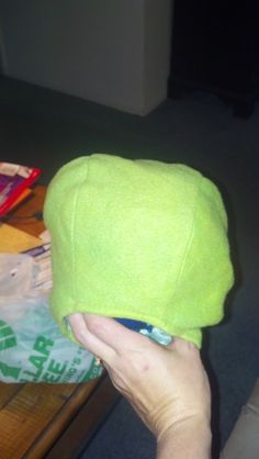 a person is holding a green hat in their hand