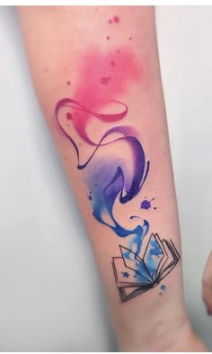 a colorful tattoo on the arm of a woman with an open book in her hand