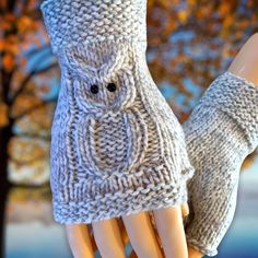 two hands wearing knitted mittens and gloves with trees in the background