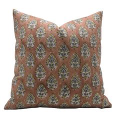 an orange pillow with blue and green designs on it's side, against a white background