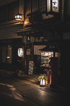 an empty street at night with lanterns lit up