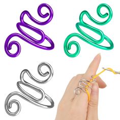 three different types of metal spirals are being held by someone's hand and pointing at them