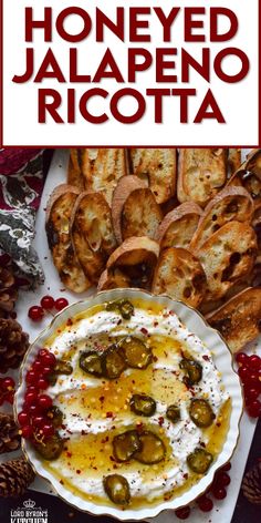 a plate with bread and olives on it next to some other foods that are in the background