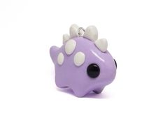 a purple toy with white and black spots on it's face, sitting in front of a white background