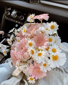 a bouquet of daisies in the passenger seat of a car