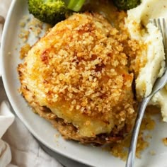 a white plate topped with mashed potatoes and broccoli