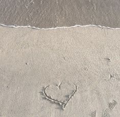 a heart drawn in the sand at the beach