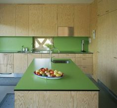 a kitchen with green counter tops and wooden cabinets