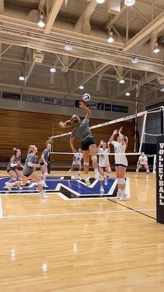 a group of women playing volleyball on a court