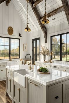 a large kitchen with white cabinets and marble counter tops, along with wooden beams on the ceiling