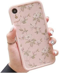 a woman holding an iphone case with flowers on it