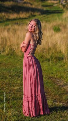 a woman in a pink dress is posing for a photo with her arms around her neck