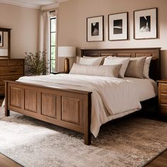 a large bed sitting in a bedroom next to two framed pictures on the wall above it