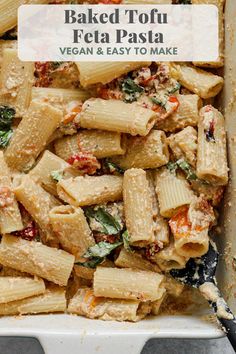 a white casserole dish filled with pasta and spinach