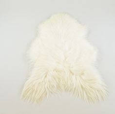 a white sheepskin rug is shown against a gray background