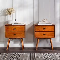 two wooden nightstands side by side against a white wall with a striped rug on the floor