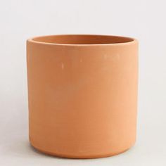 an orange cup sitting on top of a white table