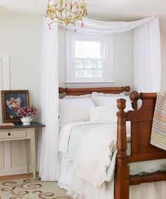 a bedroom with a bed, dresser and chandelier