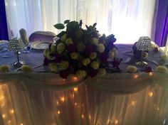 the table is set up with flowers and candles on it for an elegant wedding reception