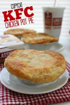 two chicken pot pies sitting on top of a white plate next to coffee cups