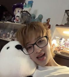 a boy with glasses holding a stuffed animal