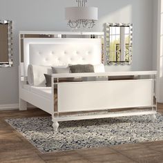 a white bed sitting on top of a wooden floor