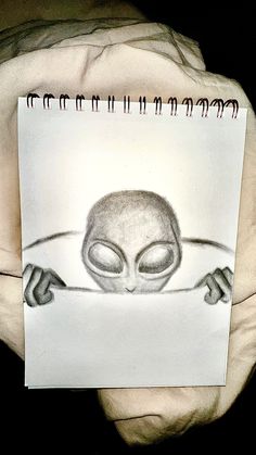 a drawing of an alien holding a piece of paper in front of his face and hands