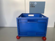 a blue plastic box with wheels on the floor