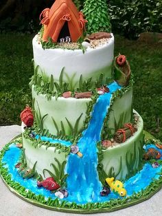 a three tiered cake decorated with an image of a waterfall and fish on it