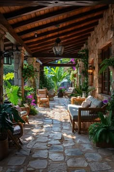 an outdoor covered patio with chairs and tables next to plants on either side of the walkway