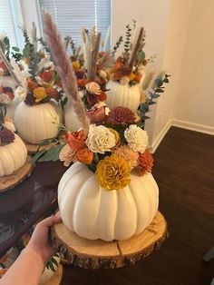 white pumpkins decorated with flowers and feathers