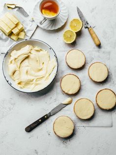 lemon shortbreads with cream cheese frosting next to tea and butter cubes