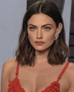 a close up of a person wearing a red dress