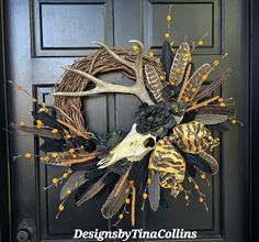 a wreath with antlers and feathers on the front door