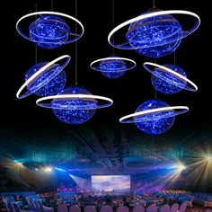 an auditorium with chairs and lights hanging from the ceiling