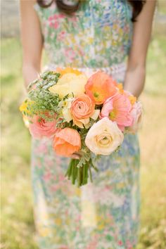 a woman holding a bouquet of flowers in her hand and wearing a dress with floral print