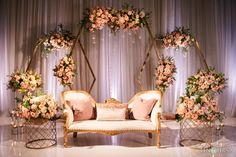 a couch with pillows and flowers on it sitting in front of a stage set up