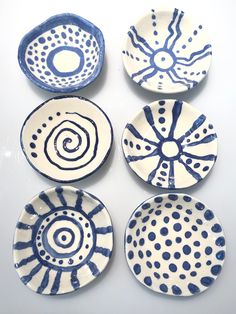 four blue and white plates with designs on them