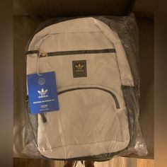 The National 2.0 Backpack From Adidas Originals Comes In A White Colorway With Black And Gold Accents Throughout. The Main Compartment Has A 16" Laptop Sleeve Within And The Smaller Compartment Has Organizers For Loose Items. Adorning The Front Is The Adidas Trefoils Logo On A Black Brand Patch For A Minimalist Look. For Secure Transportation, This Backpack Has A Top Haul Handle And Adjustable, Padded Shoulder Straps. White Nylon Bags For Streetwear, White Nylon Backpack For Streetwear, White Backpack With Zipper Closure For Streetwear, Black Bookbag, Backpack Adidas, Black And Gold Accents, Adidas Backpack, Camo Backpack, Unisex Backpack