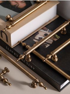 two books are sitting next to each other on a table with brass handles and pulls