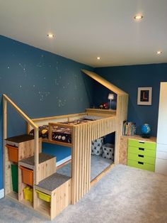 a room with blue walls and carpeted flooring has a loft bed in the corner