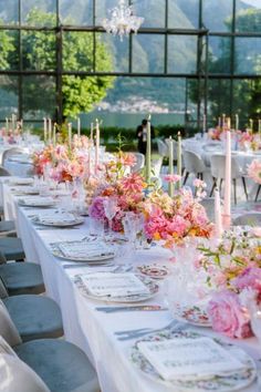 a long table set up with flowers and candles for a formal dinner or wedding reception