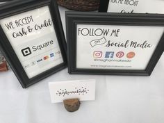 three framed signs are sitting on a table next to a sign that says follow me and social media