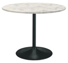 a white marble table with black metal base and an oval shaped pedestal on the top