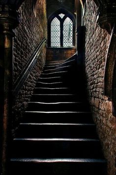 a set of stairs leading up to a window in an old building with stone walls